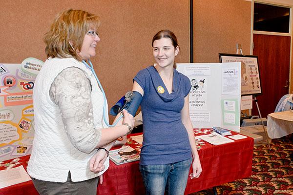 A nurse takes a student's blood pressure